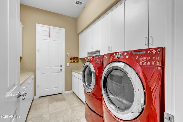 clothes washing area with visible vents, cabinet space, washer and dryer, and baseboards