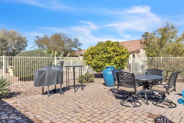 view of patio / terrace featuring outdoor dining space, fence, and a grill