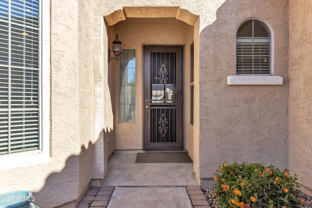 view of exterior entry featuring stucco siding