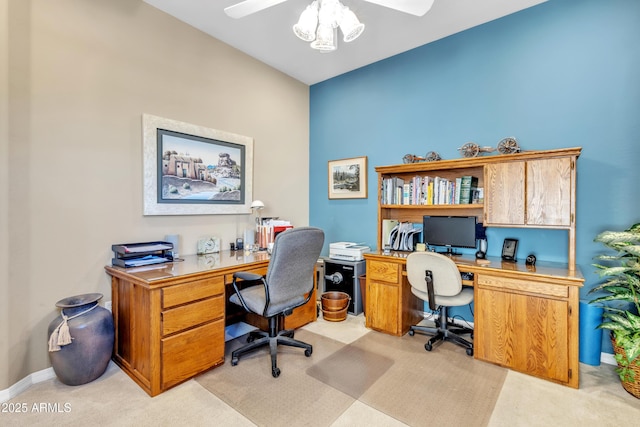 office space featuring light carpet, a ceiling fan, and baseboards