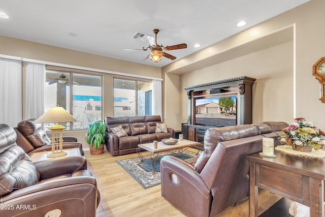 living room featuring a ceiling fan, recessed lighting, wood finished floors, and visible vents