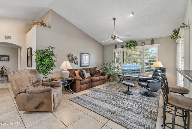 living area featuring arched walkways, light tile patterned floors, visible vents, a ceiling fan, and high vaulted ceiling