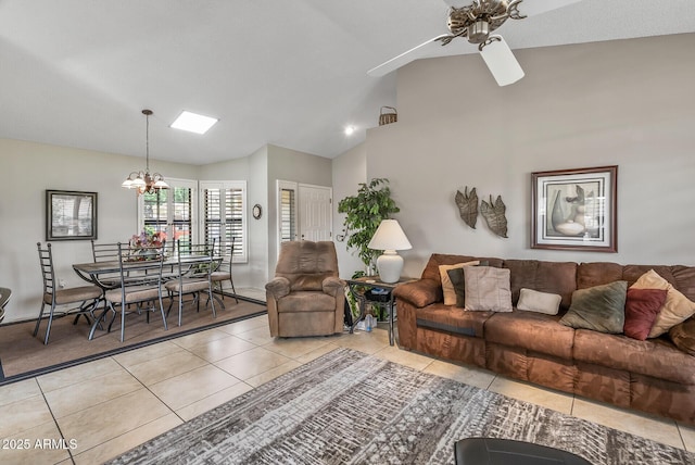 living room featuring light tile patterned floors, vaulted ceiling, and ceiling fan with notable chandelier