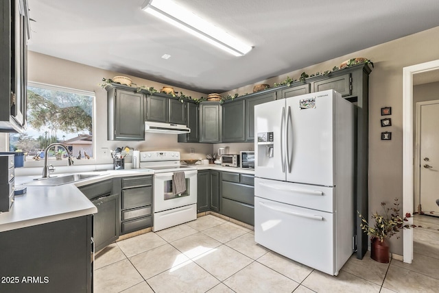 kitchen featuring light tile patterned floors, light countertops, a sink, white appliances, and under cabinet range hood