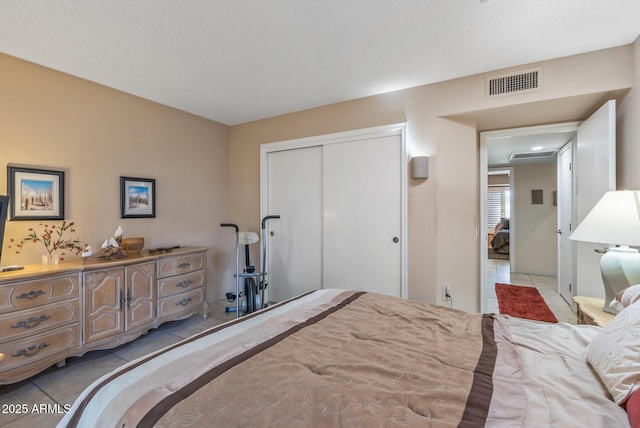 bedroom with visible vents, a closet, and light tile patterned flooring