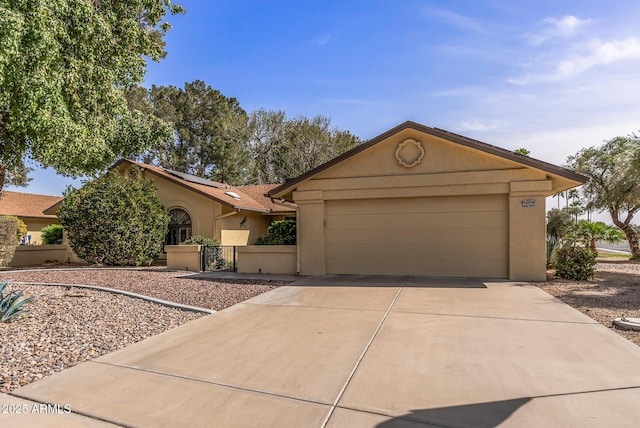 view of front of house featuring a garage, driveway, fence, and stucco siding