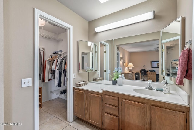 bathroom featuring a spacious closet, a skylight, vanity, and tile patterned floors