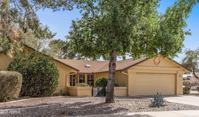 view of front facade featuring driveway, a garage, fence, and stucco siding