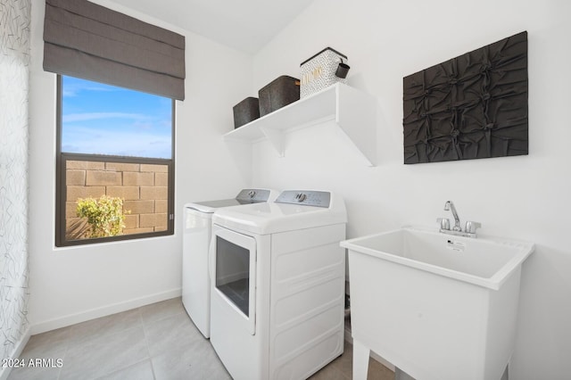 clothes washing area featuring separate washer and dryer, sink, and light tile patterned floors