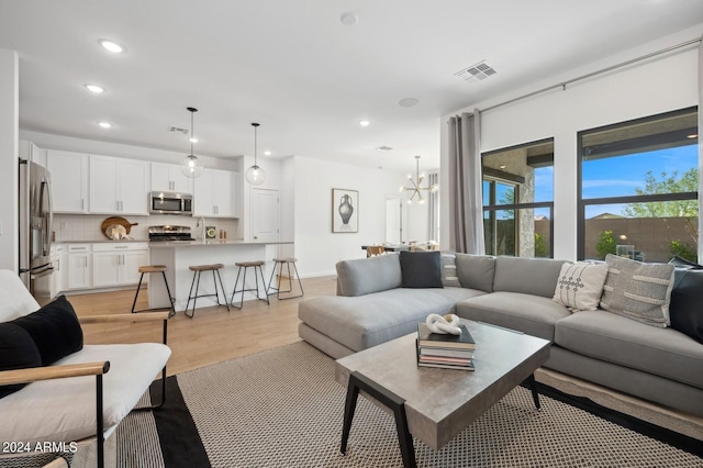 living room featuring a chandelier and light wood-type flooring