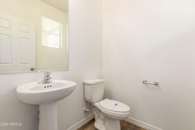 bathroom with toilet and hardwood / wood-style floors