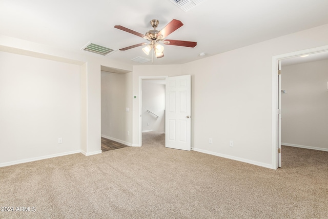 unfurnished bedroom with carpet, a spacious closet, and ceiling fan