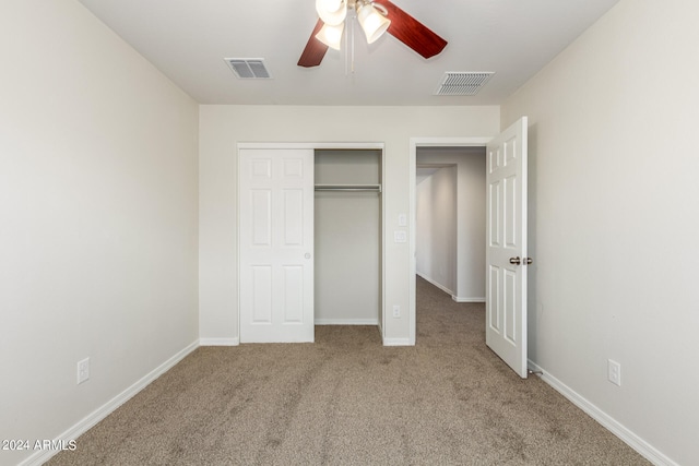 unfurnished bedroom with light carpet, ceiling fan, and a closet