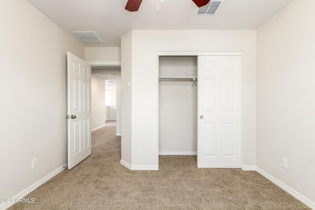 unfurnished bedroom featuring light colored carpet, ceiling fan, and a closet