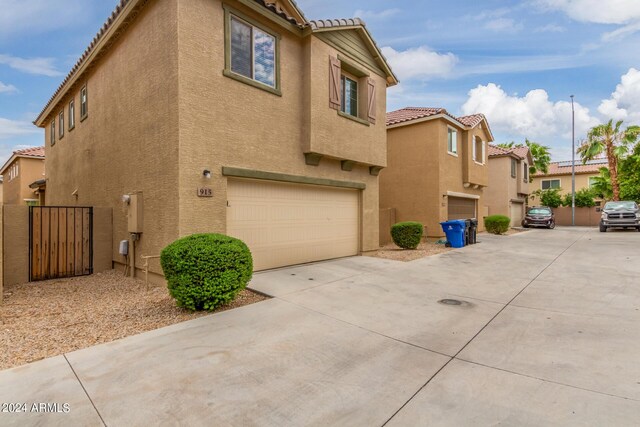 915 E Agua Fria Ln, Avondale, AZ 85323 - view of property exterior with a tile roof, stucco siding, an attached garage, and concrete driveway