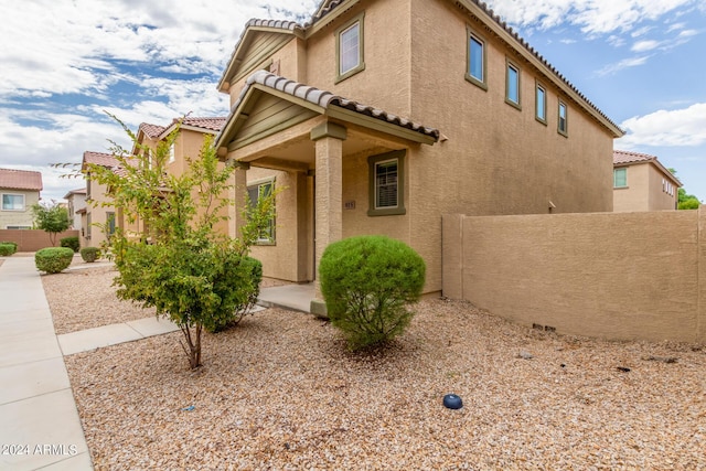 915 E Agua Fria Ln, Avondale, AZ 85323 - view of home's exterior with a tile roof, stucco siding, and fence