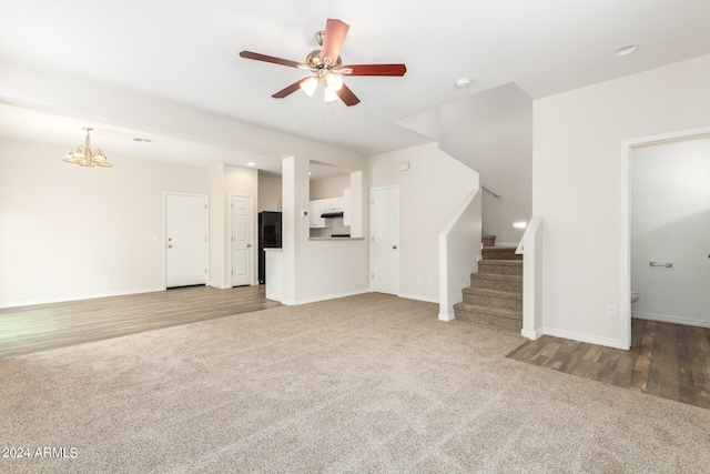 unfurnished living room featuring ceiling fan with notable chandelier and carpet