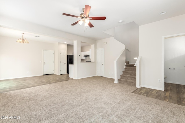 915 E Agua Fria Ln, Avondale, AZ 85323 - unfurnished living room with stairs, ceiling fan with notable chandelier, carpet, baseboards, and wood finished floors