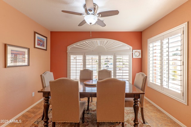 dining room with a ceiling fan and baseboards