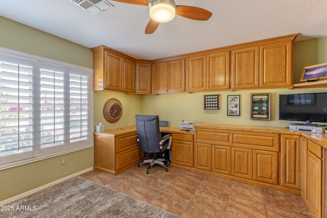 office space featuring visible vents, baseboards, built in study area, ceiling fan, and a textured ceiling