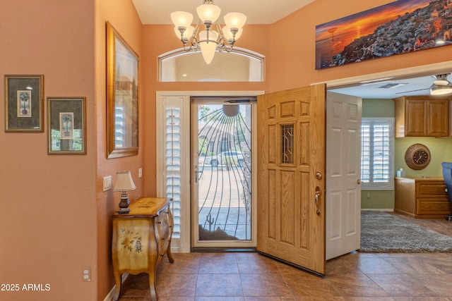 entrance foyer with light tile patterned flooring, an inviting chandelier, visible vents, and baseboards