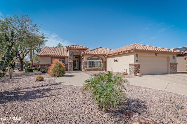 mediterranean / spanish-style home featuring a garage, stone siding, concrete driveway, and stucco siding