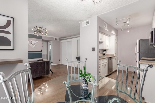 3500 N Hayden Rd Unit 801, Scottsdale, AZ 85251 - dining space featuring a textured ceiling and wood finished floors