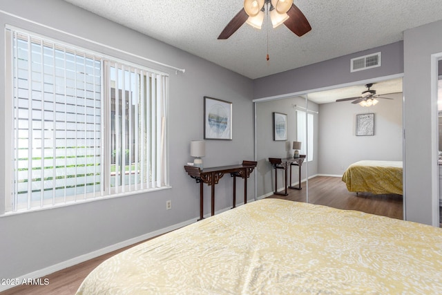 3500 N Hayden Rd Unit 801, Scottsdale, AZ 85251 - bedroom with wood finished floors, a closet, baseboards, a ceiling fan, and a textured ceiling