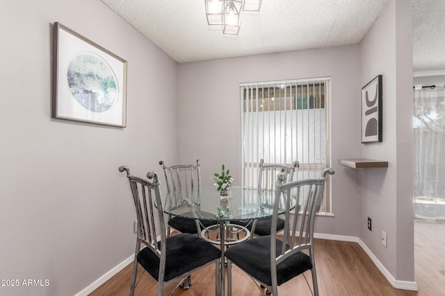 3500 N Hayden Rd Unit 801, Scottsdale, AZ 85251 - dining room with wood finished floors, a textured ceiling, and baseboards
