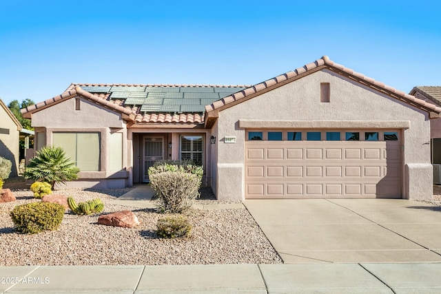 view of front of property featuring solar panels and a garage