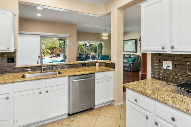 kitchen featuring white cabinetry, stainless steel dishwasher, light stone counters, and light tile patterned floors