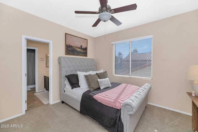 bedroom with ceiling fan, light colored carpet, and ensuite bathroom