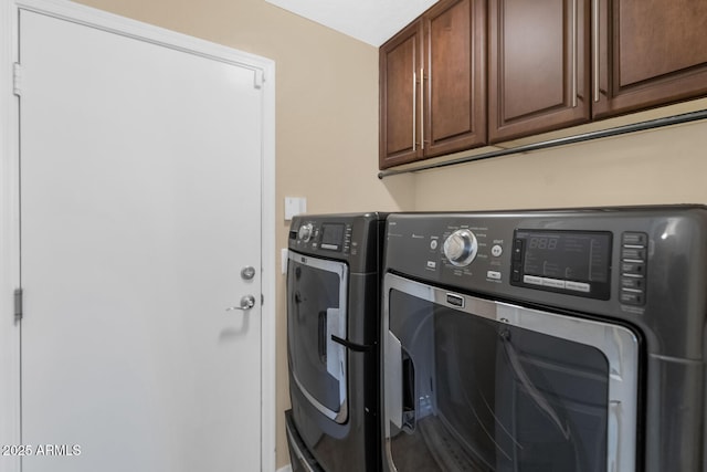 washroom with washer and clothes dryer and cabinets