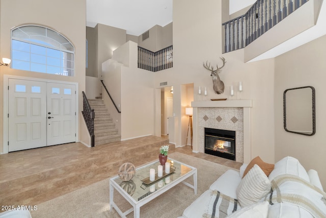 living room featuring a high ceiling and a tiled fireplace