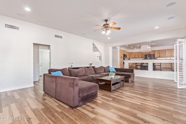 living room featuring ceiling fan and light wood-type flooring