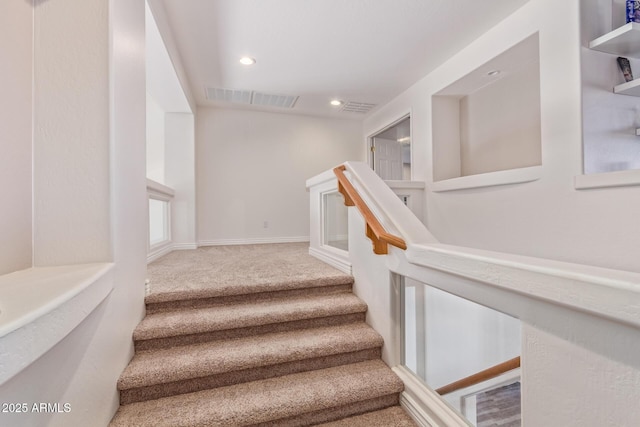 staircase featuring carpet