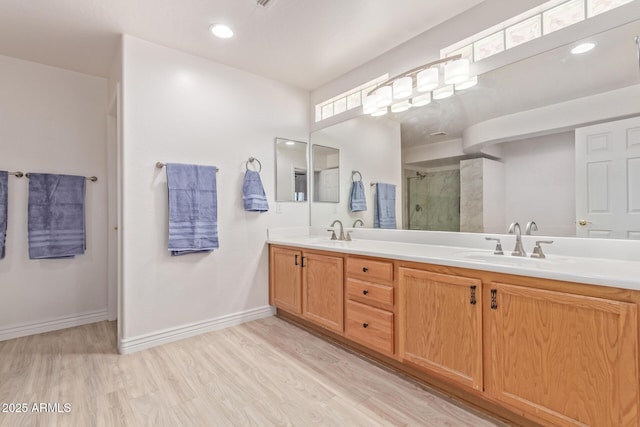 bathroom featuring hardwood / wood-style floors, vanity, and a shower with shower door