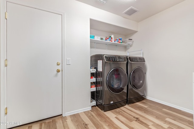 laundry room with washer and dryer and hardwood / wood-style flooring