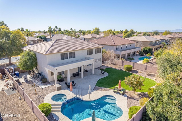 back of house featuring a yard, a patio area, outdoor lounge area, and a swimming pool with hot tub