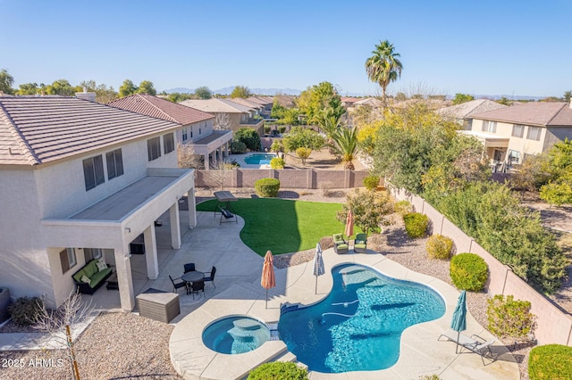 view of pool featuring an in ground hot tub, a yard, and a patio