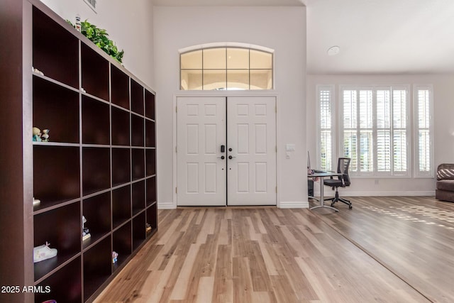 foyer entrance featuring hardwood / wood-style floors and a high ceiling