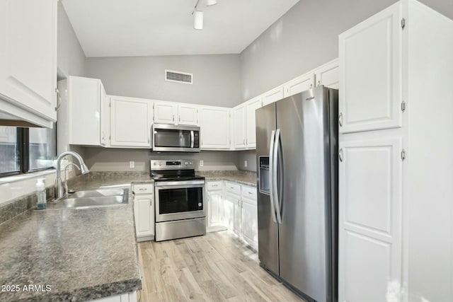 kitchen featuring light wood-type flooring, sink, stainless steel appliances, and white cabinetry