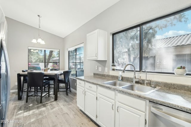 kitchen featuring appliances with stainless steel finishes, vaulted ceiling, a chandelier, white cabinets, and sink