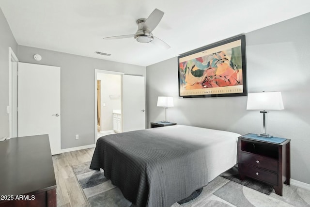 bedroom with ceiling fan, ensuite bathroom, and light wood-type flooring