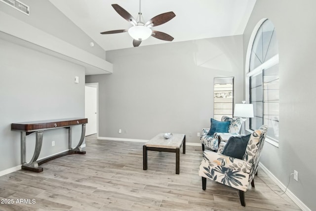 living area with ceiling fan, light hardwood / wood-style floors, and lofted ceiling