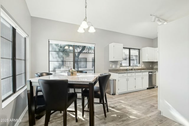 dining room featuring a notable chandelier, a healthy amount of sunlight, light hardwood / wood-style flooring, and sink