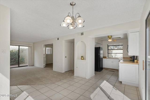 interior space featuring light tile patterned floors, visible vents, light carpet, and plenty of natural light