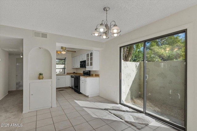 kitchen with visible vents, black appliances, white cabinets, light tile patterned flooring, and glass insert cabinets