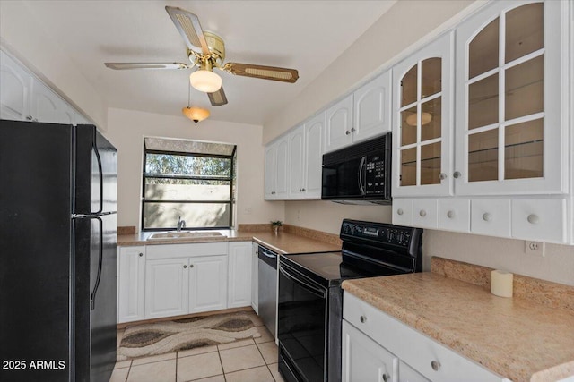 kitchen featuring a sink, glass insert cabinets, black appliances, and white cabinetry