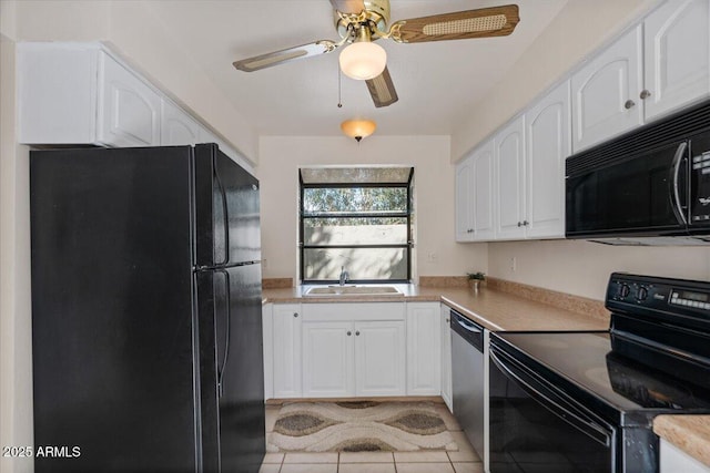 kitchen featuring white cabinets, black appliances, light countertops, and a sink